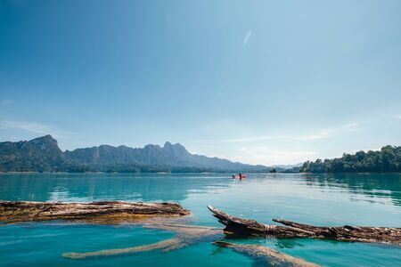 Old floating tree logs on the turquoise surface of eco lake in Thailand.の写真素材