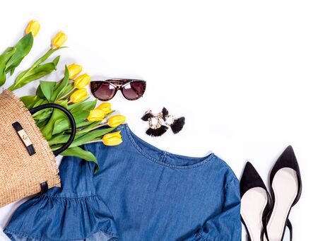 Spring summer basic denim casual city trend outfit set for woman: jeans blouse with wide sleaves, shoes, earrings, sunglasses and handbag full of yellow tulips.の写真素材
