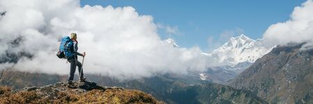 Young hiker backpacker woman using trekking poles enjoying the Nuptse 7861m mountain during high altitude Acclimatization walk.の写真素材
