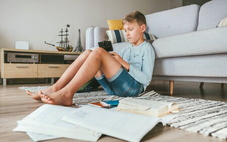 Preteen boy lost in gamepad with smartphone game on a Global Coronavirus COVID-19 pandemic lockdown...