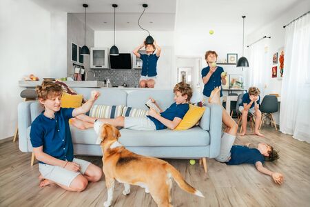 Whole day in one photo: young teen boy spending quarantine lockdown time at home.He playing dog, reading books, boring a lot, learn a juggling, fooling. World coronavirus pandemic or stay home conceptの写真素材