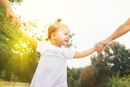 Cute little girl take hands with her relatives people.の写真素材