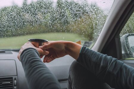 Close up shot of graceful female palms holding the hot tea tourist  mug.の写真素材