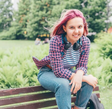 Portrait of Beautiful modern young female teenager with extraordinary hairstyle color in a checkered...
