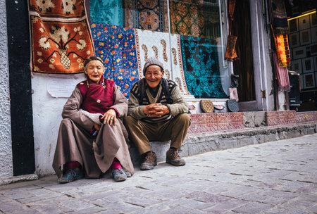 Leh , Ladakh region , India - August 20, 2016: Old Ladakhi people couple carpet sellers sitting on the street in Leh, Indiaのeditorial素材