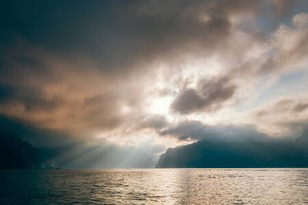 Cheow Lan Lake in the early morning under sunrise rays struggle through the storm clouds , Khao Sok national park, Thailandの写真素材
