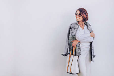 Woman in elegant outfit with oversize denim jacket. City street fashionの写真素材