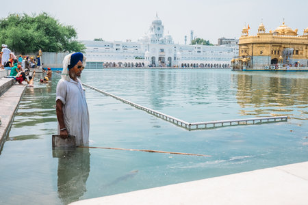 Amritsar, India - AUGUST 16: "Cleaner" of the holy pond around the Sri Harmandir Sahib or "Golden Temple" on August 16, 2016 in Amritsar, India.のeditorial素材