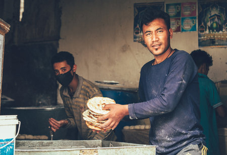 Leh , Ladakh region , India - August 20, 2016: Chapati baker preparing the fresh Flatbread on the street in Leh, Indiaのeditorial素材