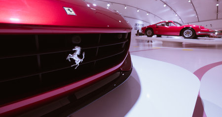 Modena, Italy - July 14, 2021: Silver prancing Ferrari horse Logo on radiator grill with Red Dino 246GT model high performance Italian sport car on background in Museo Casa Enzo Ferrari, Italy.のeditorial素材
