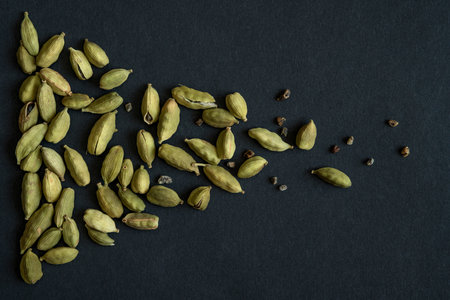 Close up photo of Cardamom pods and seeds pile on the matt black background. It is very popular in Indian and Sri Lanka cuisine.の写真素材
