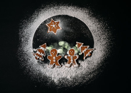Conceptual Earth planet made from sugar powder. Happy New Year and Merry Christmas concept image. Couple of ginger men walking in Christmas trees cookies forest with Star of Bethlehem above themの写真素材