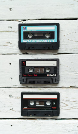 Zilina, - Slovak Republic, May 7, 2020: A image of 3 Compact Cassettes famous Magnetic audio tape manufacturers BASF, JVC and AGFA lying on white wooden table in Zilina city, Slovak Republicのeditorial素材