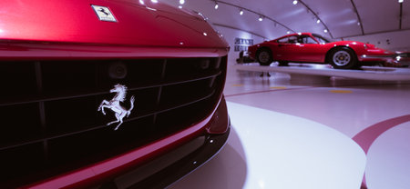Modena, Italy - July 14, 2021: Silver prancing Ferrari horse Logo on radiator grill with Red Dino 246GT model high performance Italian sport car on background in Museo Casa Enzo Ferrari, Italy.のeditorial素材