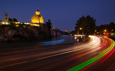 Evening Tbilisi street traffiv long exposure lights with the Statue of King Vakhtang next to the...