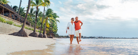 Couple in love hugging while walking on a sandy exotic beach. They have an evening walk by Trou-aux-Biches seashore on Mauritius island. People relationship and tropic honeymoon vacations conceptの写真素材