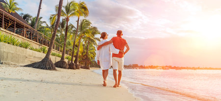 Couple in love hugging while walking on a sandy exotic beach. They have an evening walk by Trou-aux-Biches seashore on Mauritius island. People relationship and tropic honeymoon vacations conceptの写真素材