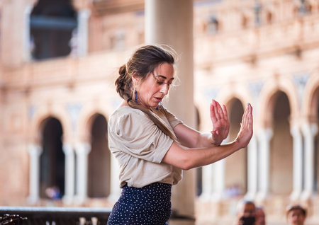 Seville, Spain - April 11, 2023: Portrait of flamenco dancer woman accompanied by street buskers guitarists on the Plaza de EspaÃ±a galleries on Spain Square, Andalusia, South Spain.のeditorial素材