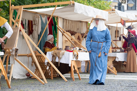 Zilina, Slovak RepubliÑ, Slovakia - July 28, 2023: Woman dressed long blue medieval dress walking by street during traditional annual restoration known as a "Stredoveky den" in Zilina, Slovakia.のeditorial素材