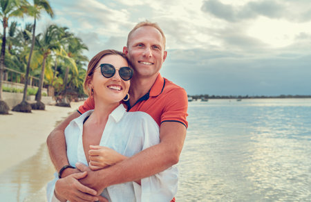 Couple in love hugging on the sandy exotic beach while they have a evening walk by the Trou-aux-Biches seashore on Mauritius island. People relationship and tropic honeymoon vacations concept image.の写真素材