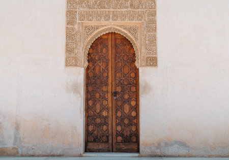 Typical wooden door and plaster carving in Court of Myrtles in Comares Palace Alhambra, Andalusia, Spain. Magic breathtaking carved decoration in Orient style.のeditorial素材