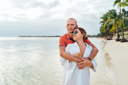 Couple in love hugging on the sandy exotic beach while they have a evening walk by the Trou-aux-Biches seashore on Mauritius island. People relationship and tropic honeymoon vacations concept image.の写真素材