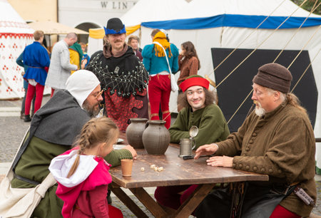 Zilina, Slovak RepubliÑ, Slovakia - July 28, 2023: Group of people dressed medieval costumes and armours at table during traditional annual restoration known as a "Stredoveky den" in Zilina, Slovakia.のeditorial素材