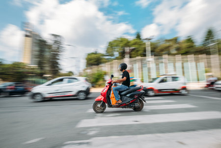 Kathmandu Urban Buzz: moto scooter on the dusty Nepalese streets blurry moving in the car traffic in...