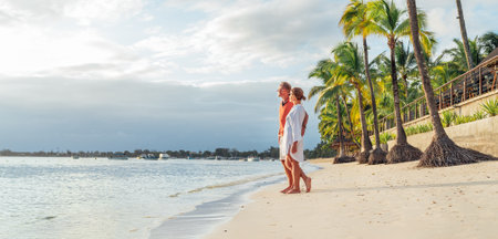 Couple in love hugging on sandy exotic beach while having evening walk by Trou-aux-Biches seashore on Mauritius island enjoying sunset. People relationship and tropic honeymoon vacations concept imageの写真素材