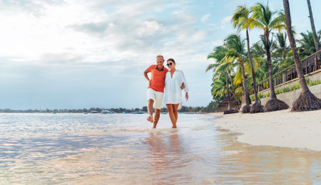 Couple in love hugging while walking on a sandy exotic beach. They have an evening walk by Trou-aux-Biches seashore on Mauritius island. People relationship and tropic honeymoon vacations conceptの写真素材