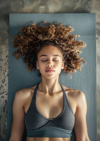Top view photo of beautiful yoga adept woman while she meditates in shavasana pose doing breathing exercises. Active people, Oriental practices in common life, relaxing or mental health concept imageの素材