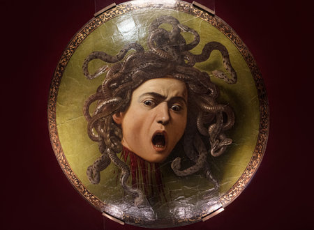 Florence, Italy - May 23, 2023: Famous Painting masterpiece of Medusaâs head with snakes hair, mouth agape in terror, displayed on a round shield by Baroque painter Caravaggio in Uffizi Gallery, Italyのeditorial素材
