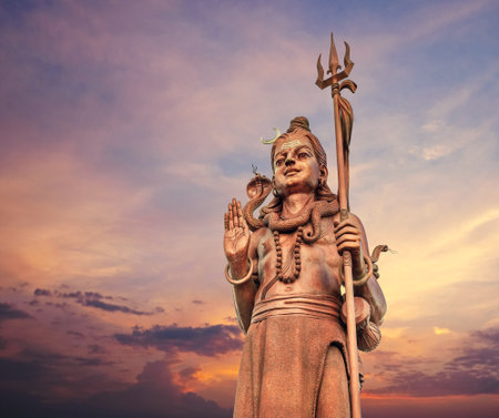 The huge Shiva statue Mangal Mahadev is a 33 m art piece in Ganga talao temple on the blue evening sunset sky, Mauritius island.の写真素材