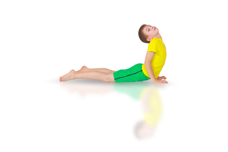 little boy doing yoga on white backgroundの写真素材