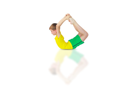 little boy doing yoga on white backgroundの写真素材