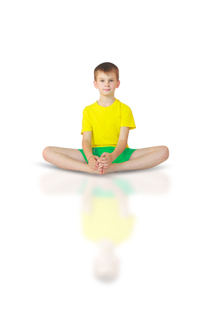 little boy doing yoga on white backgroundの写真素材