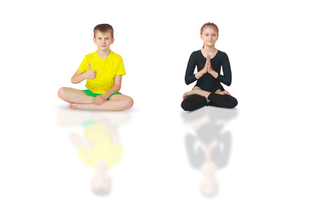 little boy and girl doing yoga on white backgroundの写真素材