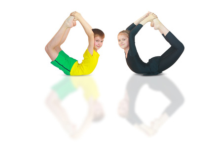 little boy and girl doing yoga on white backgroundの写真素材