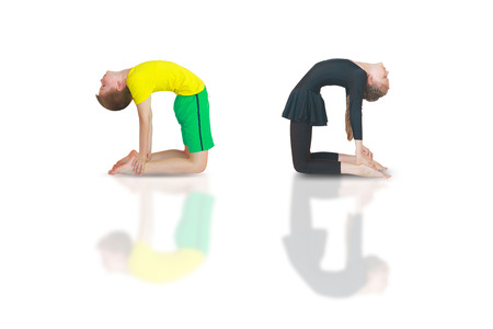 little boy and girl doing yoga on white backgroundの写真素材