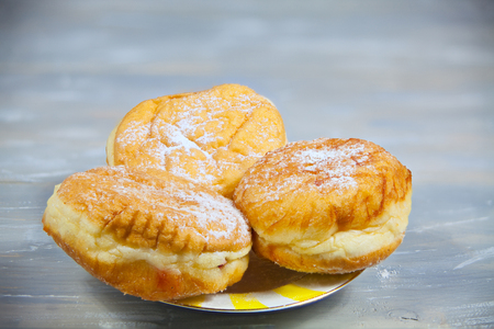 delicious appetizing Doughnuts with stuffed on plate on wooden backgroundの写真素材