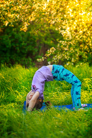 beautiful girl doing yoga outdoors On the green grassの写真素材