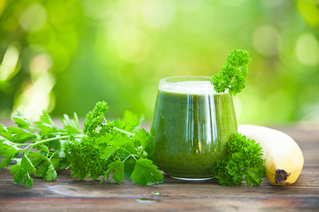 parsley and celery juice in glass on wooden tableの写真素材