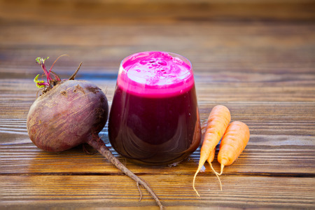 beet-Carrot juice in glass on wooden tableの写真素材
