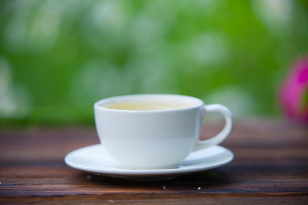 porcelain cup with green tea on a tableの写真素材