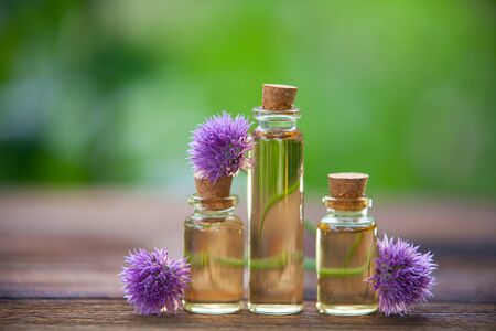 Chives essential oil in a beautiful bottle on the wooden backgroundの写真素材