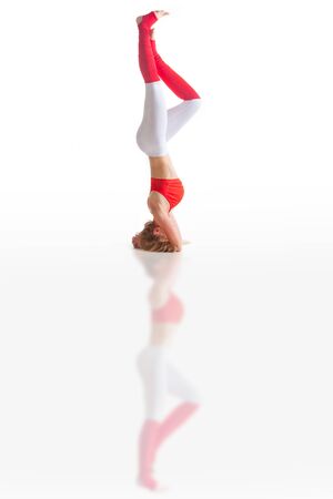 beautiful flexible woman doing yoga poses on white backgroundの写真素材