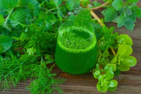 Green herb smoothie on a wooden brown tableの写真素材