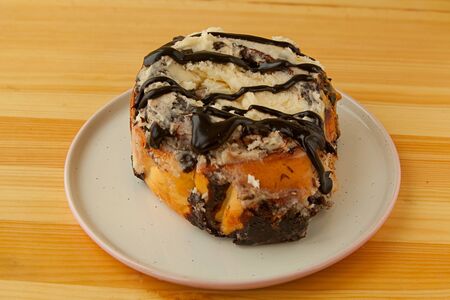roll with cinnamon on a plate on a wooden background