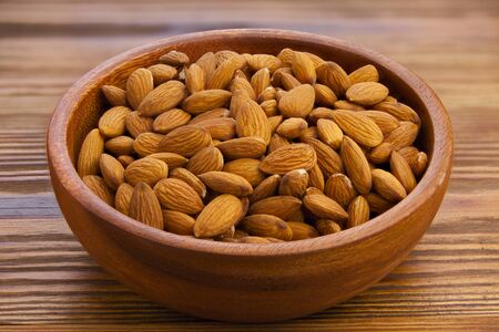 delicious almond nut on a plate on a wooden backgroundの写真素材
