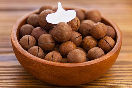 delicious macadamia nuts on a plate on a wooden backgroundの写真素材
